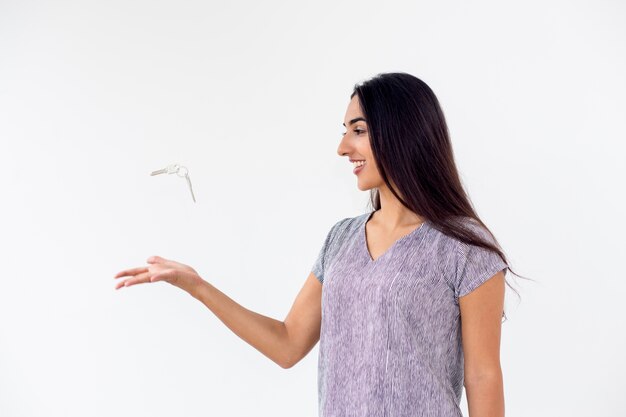 Photo gratuite bonne jeune femme jetant les clés de voiture ou de maison