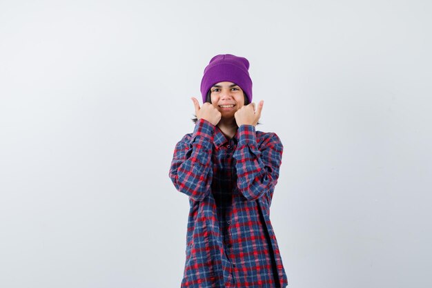 Bonnet petite femme montrant les pouces vers le haut à la joyeuse