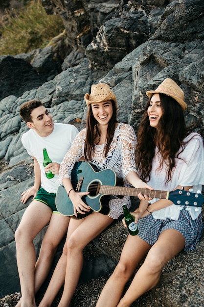 Photo gratuite bons amis à la plage avec guitare