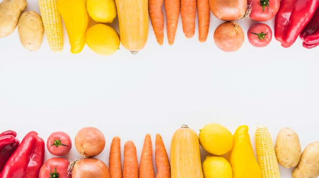 Bordure supérieure et inférieure faite avec des légumes sur fond blanc