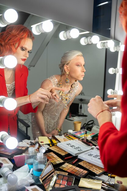 Bouchent les drag queens regardant dans un miroir