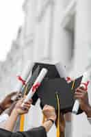 Photo gratuite bouchent les mains tenant des diplômes et des casquettes