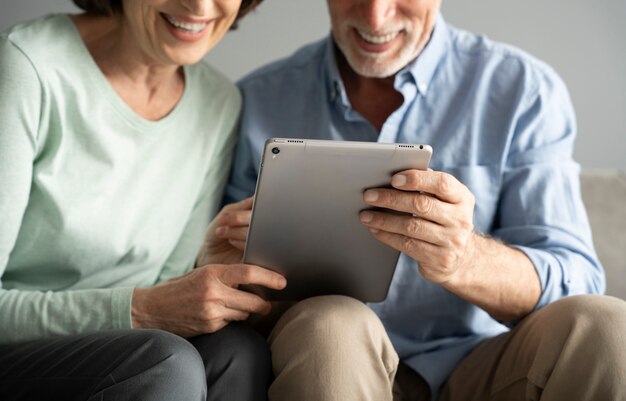 Bouchent les personnes âgées souriantes avec tablette