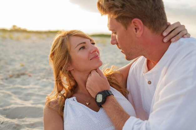 Bouchent le portrait de beau couple européen embrassant contre le coucher du soleil.