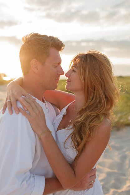 Bouchent le portrait de beau couple européen embrassant contre le coucher du soleil.