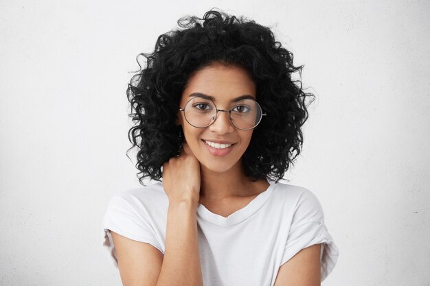 Bouchent le portrait d'une belle étudiante à la peau foncée et aux cheveux hirsutes noirs