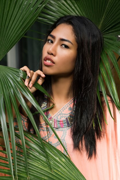 Bouchent le portrait de la belle femme thaïlandaise sur les feuilles tropicales. Concept de spa et de détente Style bohème ethnique.