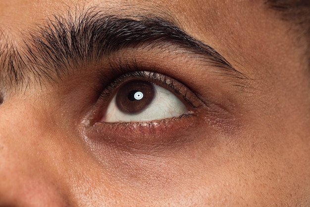 Bouchent le portrait du visage de jeune homme hindou aux yeux bruns regardant vers le haut ou sur le côté