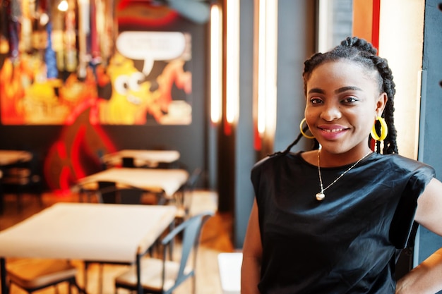 Bouchent portrait femme africaine en blouse noire au café.