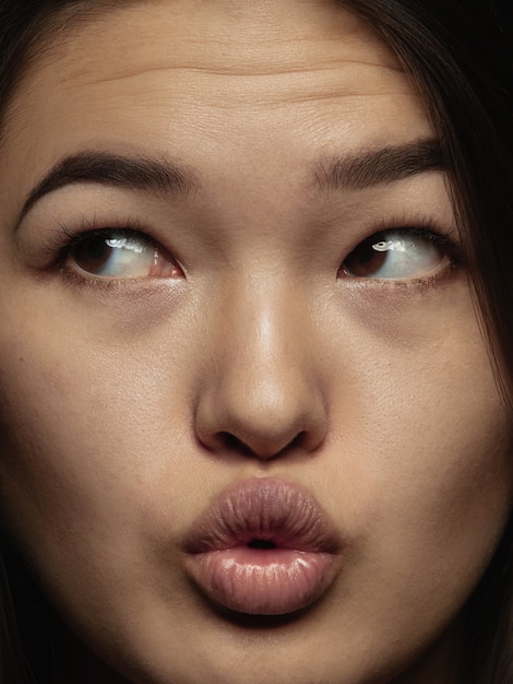 Bouchent le portrait d'une femme chinoise jeune et émotionnelle. Séance photo très détaillée d'un modèle féminin avec une peau bien entretenue et une expression faciale brillante. Concept d'émotions humaines. Envoi de bisous.