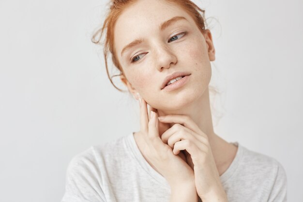 Bouchent le portrait d'une femme tendre au gingembre rêvant souriant.