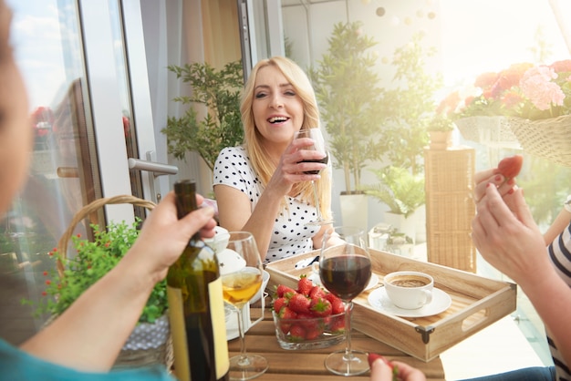 Bouchent le portrait de femmes vin sur le balcon