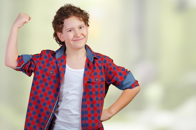 Photo gratuite bouchent le portrait d'un garçon souriant fort montrant des muscles