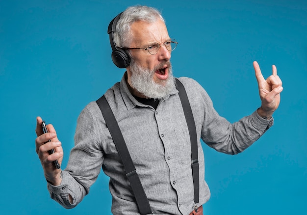 Photo gratuite bouchent le portrait d'un homme âgé écoutant de la musique