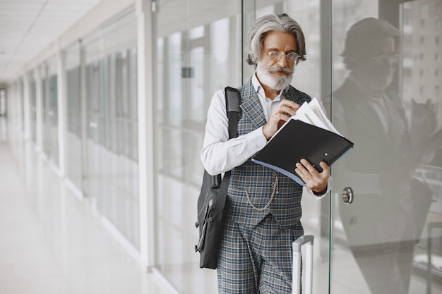 Bouchent le portrait d'un homme à l'ancienne souriant. Homme élégant au bureau. Senior avec un document.