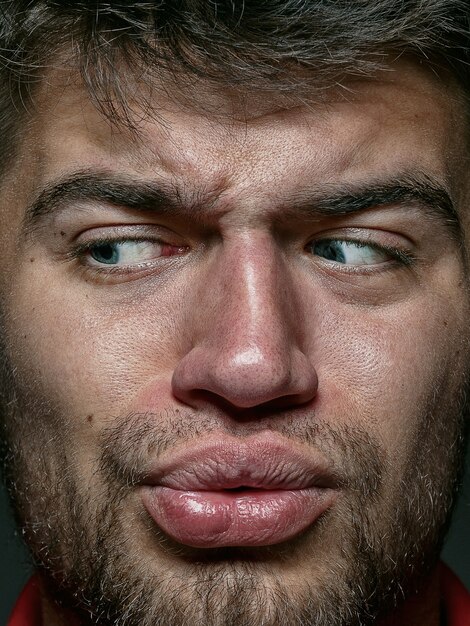 Bouchent le portrait d'un homme caucasien jeune et émotionnel. modèle masculin avec une peau bien entretenue et une expression faciale brillante. Concept d'émotions humaines. Sentiment dégoûtant.