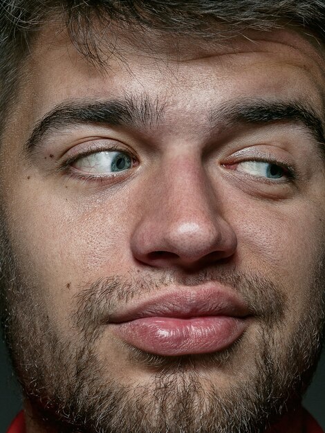 Bouchent le portrait d'un homme caucasien jeune et émotionnel. Photo très détaillée d'un modèle masculin avec une peau bien entretenue et une expression faciale brillante. Concept d'émotions humaines. Ça a l'air ludique.