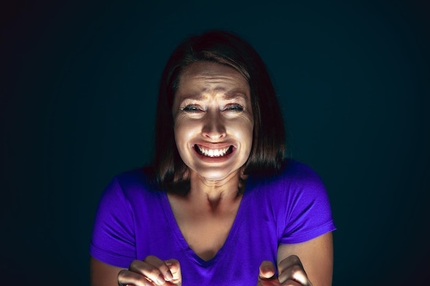 Photo gratuite bouchent le portrait d'une jeune femme folle effrayée et choquée isolée sur l'obscurité