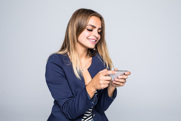 Bouchent le portrait d'une jeune femme heureuse, jouer à des jeux sur téléphone mobile isolé