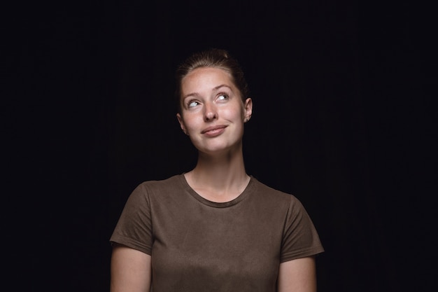 Bouchent le portrait de jeune femme isolée sur fond noir de studio.