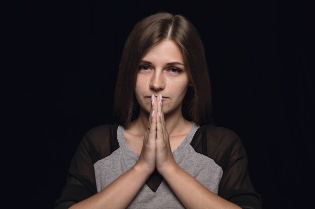 Bouchent le portrait de jeune femme isolée sur mur noir