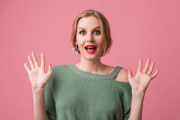 Bouchent le portrait de jeune femme portant un pull vert avec des lèvres rouges sur rose