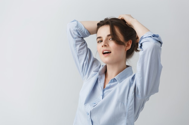 Bouchent Le Portrait De La Jeune Femme Se Faisant Une Coiffure Avec Une Expression Heureuse Et Joyeuse.