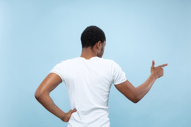 Bouchent le portrait de jeune homme afro-américain en chemise blanche. Affichage de la barre vide, pointant, choisissant, invitant.