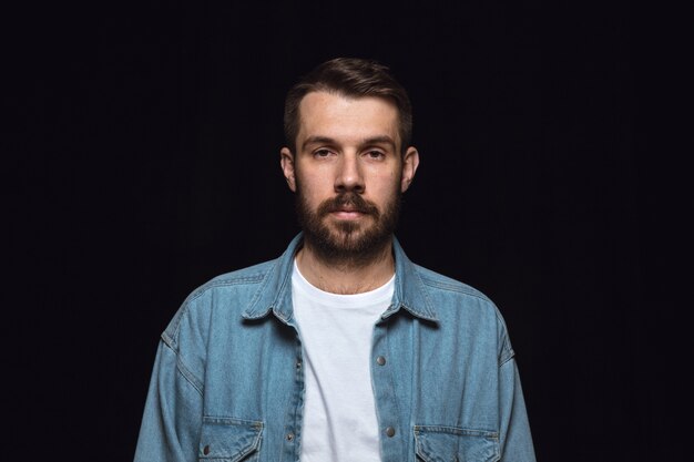 Bouchent le portrait de jeune homme isolé sur studio noir