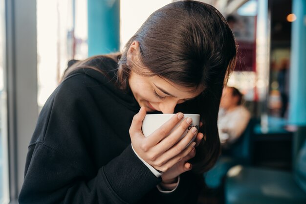 Bouchent le portrait d'une jolie femme buvant du café.