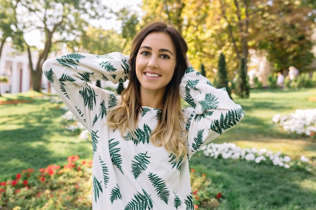 Bouchent le portrait de la jolie jeune femme dans le parc d'automne vêtue d'une belle robe