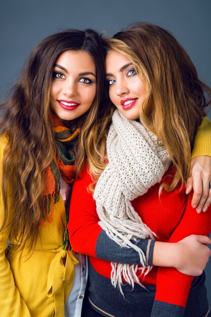 Bouchent le portrait de mode des gars élégants avec du maquillage à la mode portant des vêtements décontractés élégants et de grandes écharpes chaudes. Mode portrait d'hiver des meilleures soeurs d'amis.