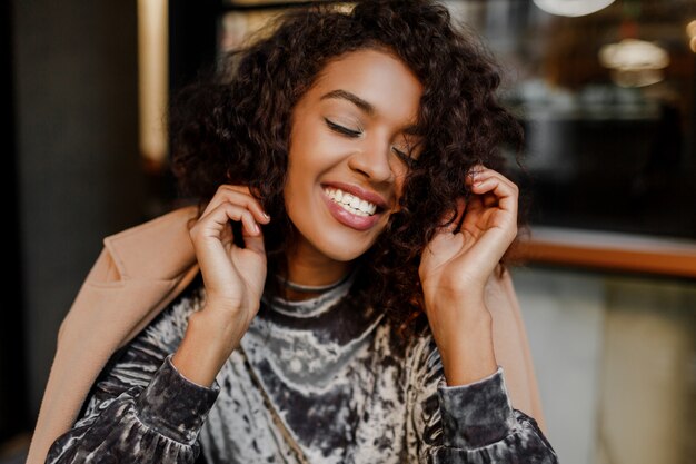 Bouchent le portrait de mode de vie d'une femme noire insouciante heureuse, profitant d'une pause-café à Paris.