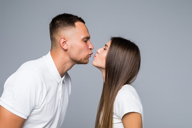 Bouchent le portrait de petit ami baiser petite amie isolée sur fond gris