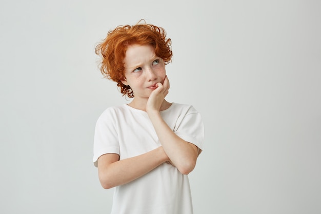 Bouchent portrait de petit garçon au gingembre avec des taches de rousseur pensivement à côté de se souvenir