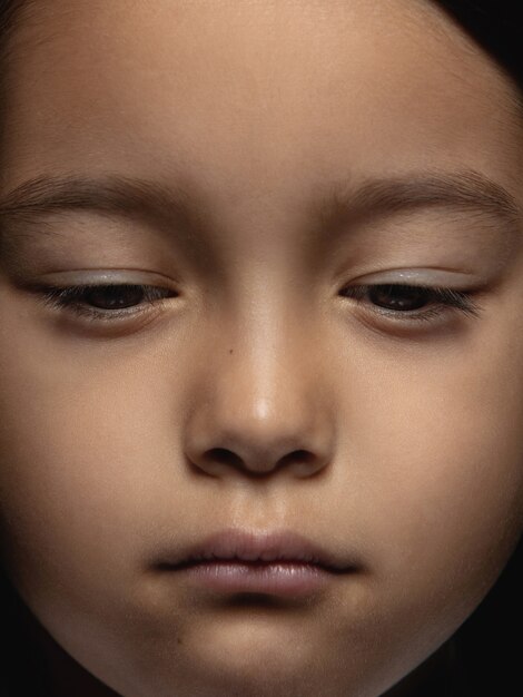 Bouchent le portrait de petite fille asiatique émotionnelle. Photo très détaillée d'un modèle féminin avec une peau bien entretenue et une expression faciale brillante. Concept d'émotions humaines. Ça a l'air triste, bouleversé.