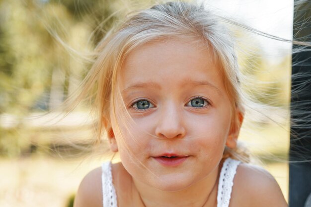 Bouchent le portrait d'une petite fille blonde un jour d'été