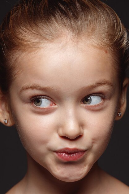 Bouchent le portrait de petite fille caucasienne et émotionnelle. Photo très détaillée d'un modèle féminin avec une peau bien entretenue et une expression faciale brillante. Concept d'émotions humaines. Grémaces ludiques.