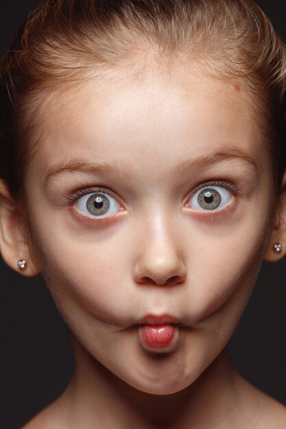 Bouchent le portrait de petite fille caucasienne et émotionnelle. Séance photo très détaillée d'un modèle féminin avec une peau bien entretenue et une expression faciale brillante. Concept d'émotions humaines. Grémaces ludiques.