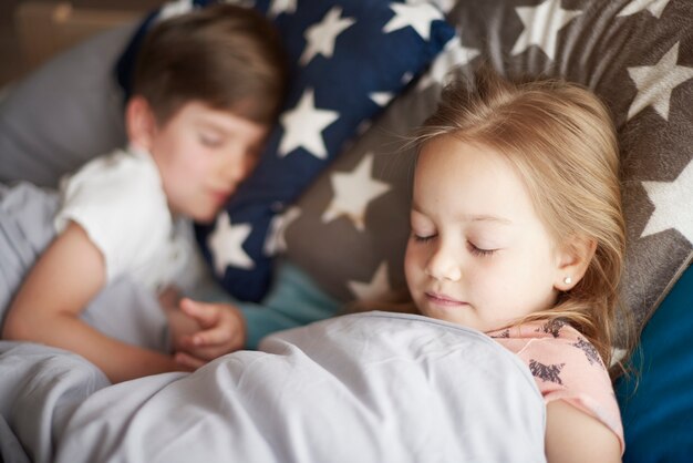 Bouchent le portrait de petite fille endormie à côté de son frère