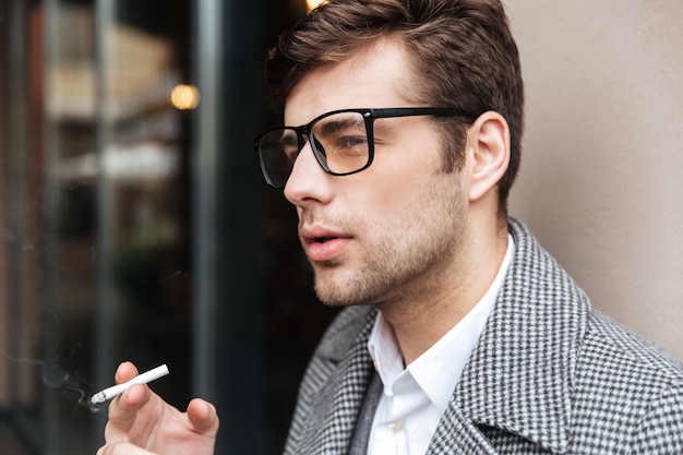 Bouchent La Vue De Côté D'homme D'affaires Sérieux à Lunettes