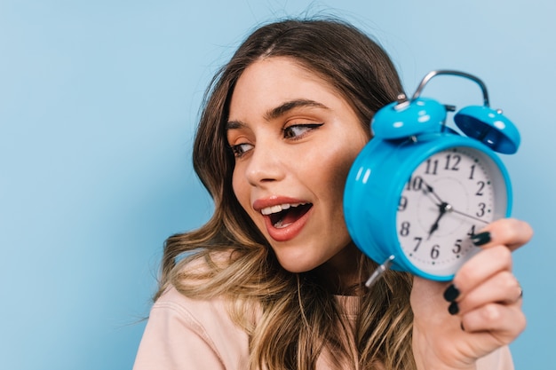 Bouchent la vue de la femme attrayante avec horloge