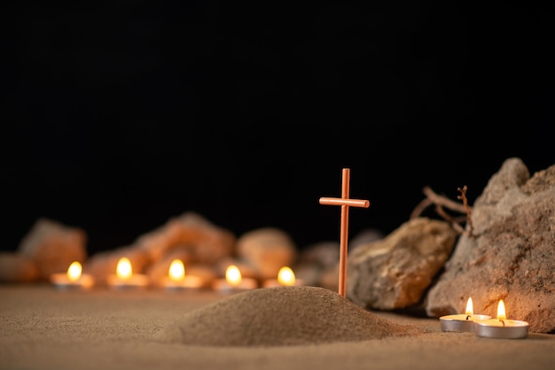 Des bougies allumées avec des pierres autour de la petite tombe comme funérailles de mort de mémoire