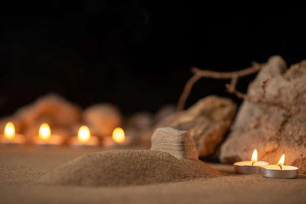 Des bougies allumées avec des pierres autour de la petite tombe comme mort funéraire mémoire