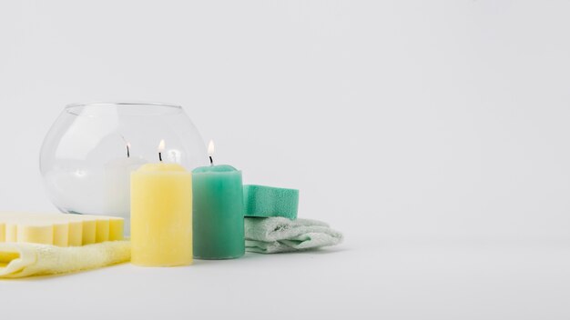 Bougies colorées lumineuses avec éponge et serviette isolé sur fond blanc