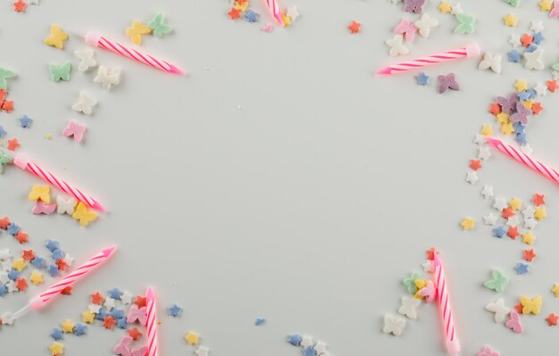 Bougies de gâteau avec des paillettes sucrées sur un tableau blanc