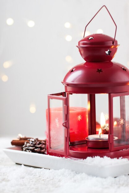 Bougies de Noël avec des cônes de sapin, lanterne, décoration de Noël et neige, hiver ou concept de vacances