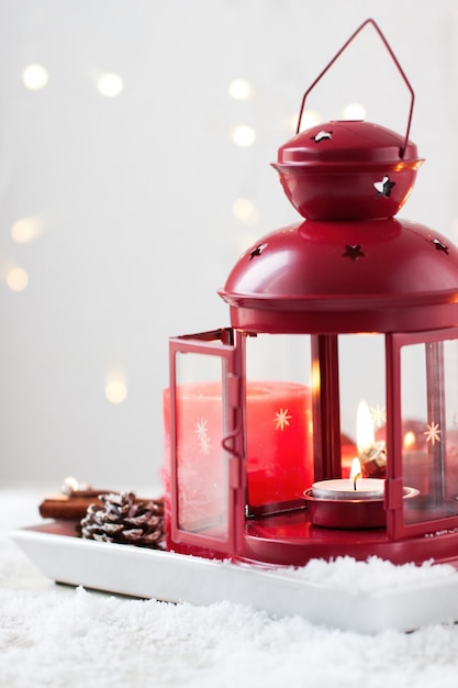 Bougies de Noël avec des cônes de sapin, lanterne, décoration de Noël et neige, hiver ou concept de vacances