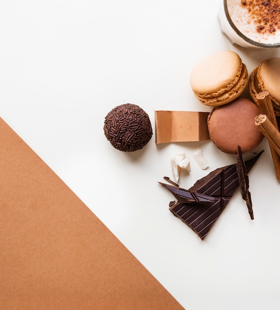 Boule de chocolat; macarons et verre à café avec des ingrédients sur fond blanc