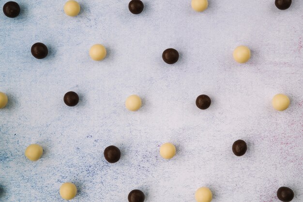 Boules de chocolat blanc et noir sur fond de béton